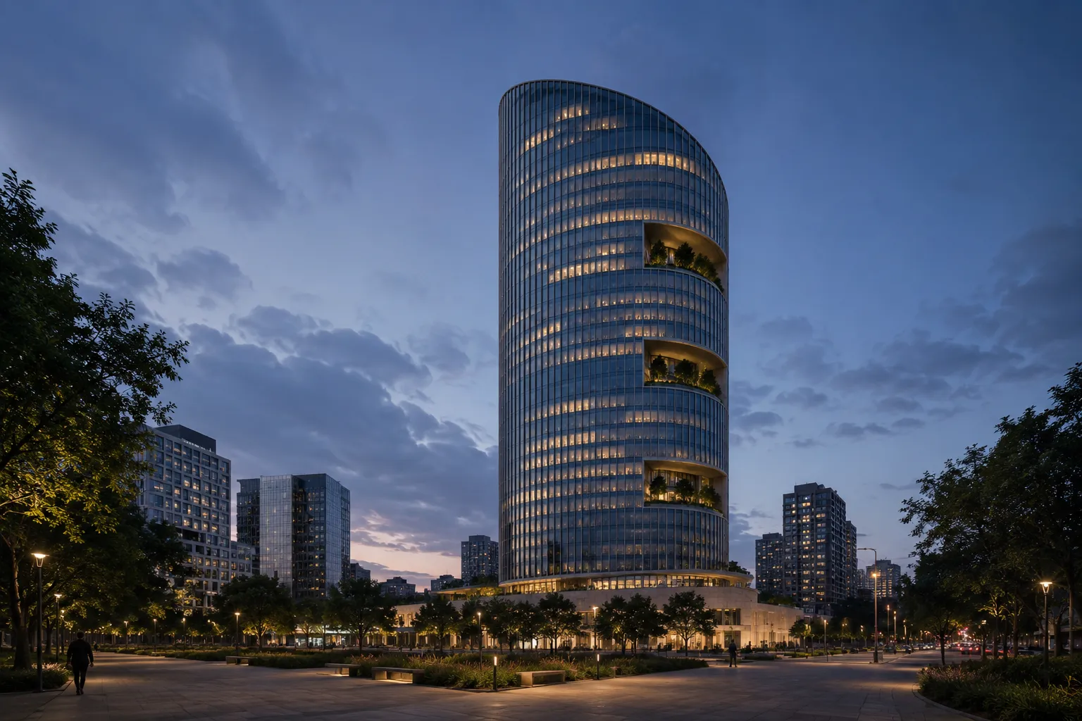 Vista urbana nocturna de Estrato 38 desde una plaza arbolada, con la torre iluminada y edificios vecinos